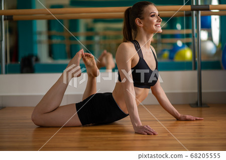 young fitness model stretches in a fitness club young fitness model stretches in a fitness club 68205555