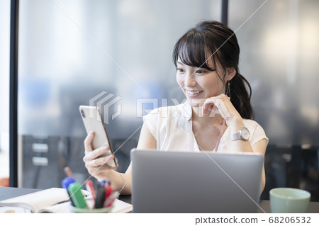 一個喜歡在辦公室裡操作智能手機的女人 一個喜歡在辦公室裡操作智能手機的女人 68206532