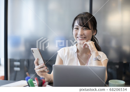 一個喜歡在辦公室裡操作智能手機的女人 一個喜歡在辦公室裡操作智能手機的女人 68206534