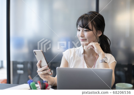 一個喜歡在辦公室裡操作智能手機的女人 68206536