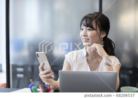 一個喜歡在辦公室裡操作智能手機的女人 一個喜歡在辦公室裡操作智能手機的女人 68206537