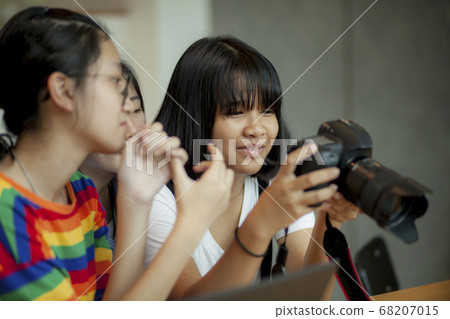 asian teenager looking on back screen of dslr asian teenager looking on back screen of dslr 68207015