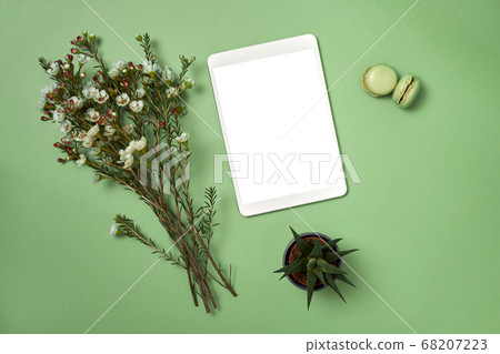Flat lay notepad and flowers and macaroons on green background  68207223