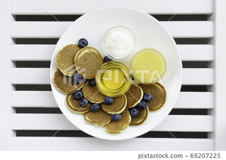 Pancake cereal with honey, yogurt, milk and blueberry. Pancake cereal with honey, yogurt, milk and blueberry. 68207225