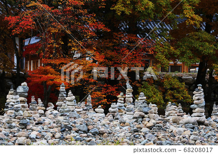 在精心堆砌的石塔後面,秋天的樹葉被淡淡的 在精心堆砌的石塔後面,秋天的樹葉被淡淡的 68208017