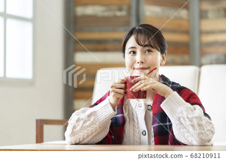 一杯熱飲料的年輕女子 68210911