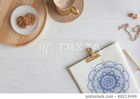 Decorative round floral mandala drawn on a white sheet. Home relaxation, hobby and rest. Coffee and cookies on a white background. Decorative round floral mandala drawn on a white sheet. Home relaxation, hobby and rest. Coffee and cookies on a white background. 68213499