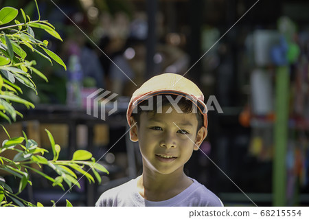 Portrait of Asian boy wearing a red cap and white  shirt is smile. 68215554
