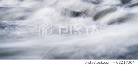 Long exposure photo - water flowing over rocks everything smooth, only few waterdrops in focus 68217304