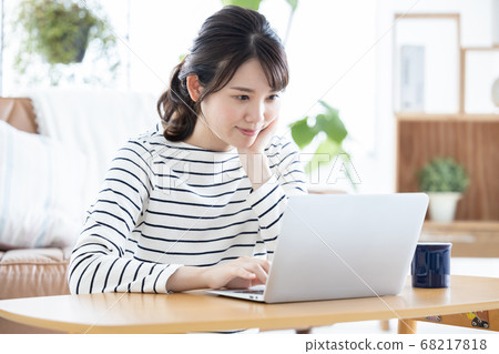 Lifestyle Woman sitting on the floor and looking at laptop Lifestyle Woman sitting on the floor and looking at laptop 68217818