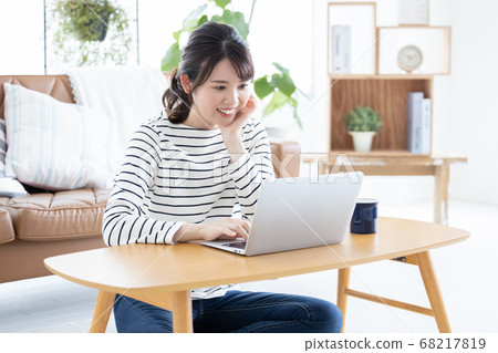 Lifestyle Woman sitting on the floor and looking at laptop Lifestyle Woman sitting on the floor and looking at laptop 68217819