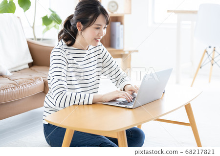 Lifestyle Woman sitting on the floor and looking at laptop 68217821