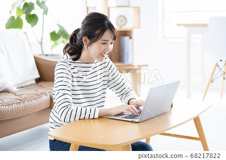 Lifestyle Woman sitting on the floor and looking at laptop 68217822