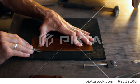 Man holding crafting tool and working. 68218106