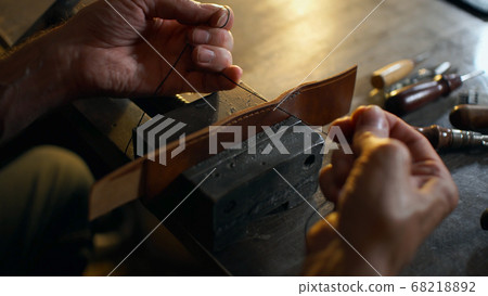 Artisan working with leather. 68218892