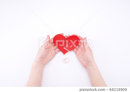 Female hands hold a broken heart on a white Female hands hold a broken heart on a white 68218909