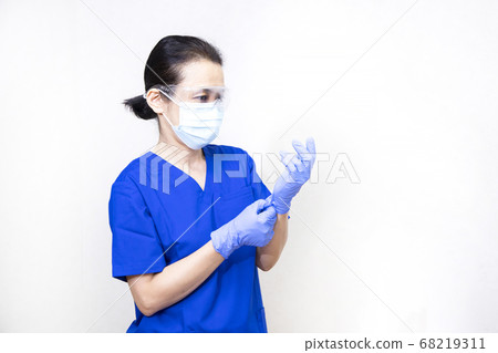 Medical personnel wearing goggles, masks and gloves Medical personnel wearing goggles, masks and gloves 68219311