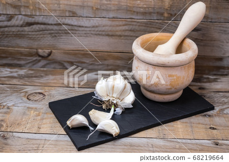 cooking ingredients and spices like garlic over a board to cut and prepare them for cooking 68219664