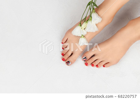 Manicure, pedicure beauty salon concept. Womans feet on gray Manicure, pedicure beauty salon concept. Womans feet on gray 68220757