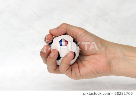 Mini football in hand and one black point of football is France flag on white background. Mini football in hand and one black point of football is France flag on white background. 68221706