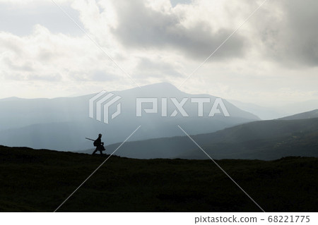 A silhouette of a photographer with a tripod A silhouette of a photographer with a tripod 68221775