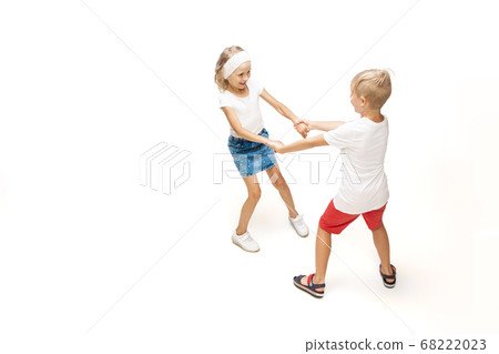 Happy little caucasian girl and boy jumping and running isolated on white background Happy little caucasian girl and boy jumping and running isolated on white background 68222023