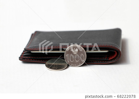Two coins of one thousand Indonesia Rupiah with black wallet on white floor. Two coins of one thousand Indonesia Rupiah with black wallet on white floor. 68222078