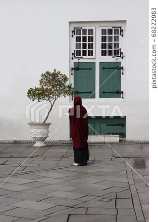 BehinBehind of muslim woman Indonesian standing with green window. BehinBehind of muslim woman Indonesian standing with green window. 68222083