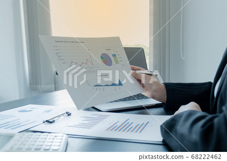 Businesswoman calculating financial graph showing results in the office Businesswoman calculating financial graph showing results in the office 68222462
