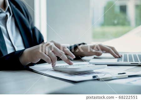 Businesswoman calculating financial graph showing results in the office Businesswoman calculating financial graph showing results in the office 68222551