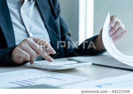 Businesswoman calculating financial graph showing results in the office Businesswoman calculating financial graph showing results in the office 68222566