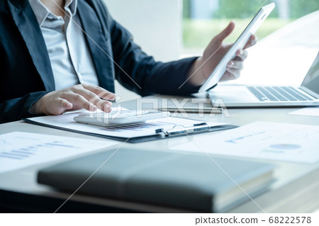 Businesswoman calculating financial graph showing results in the office Businesswoman calculating financial graph showing results in the office 68222578