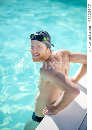 Satisfied man standing in water in pool Satisfied man standing in water in pool 68223407