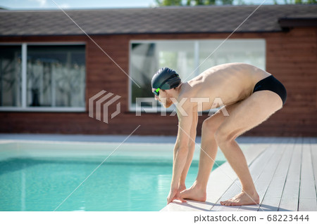 Man in profile by the pool before diving 68223444