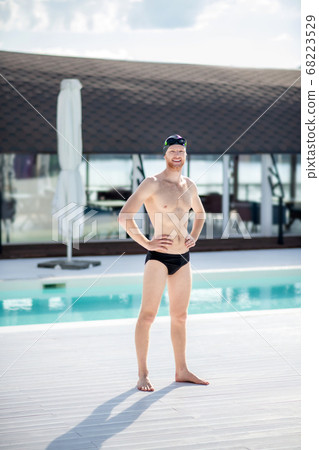 Man in swimming suit barefoot standing hands on waist Man in swimming suit barefoot standing hands on waist 68223529
