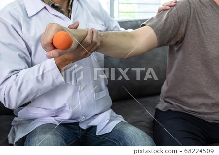 Doctor physiotherapist treating arm pain patient 68224509