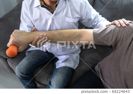 Doctor physiotherapist treating arm pain patient 68224643