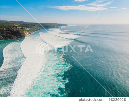 Surfing waves in ocean and coastline of Bali. Aerial view of surf spot. 68226028