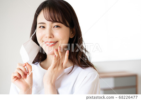 Young woman trying to put on a mask in the morning Young woman trying to put on a mask in the morning 68226477