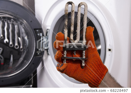 Repair of washing machines. Hand of a repairman 68228497
