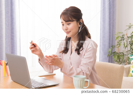 A young woman making a web conference using a laptop computer in telework A young woman making a web conference using a laptop computer in telework 68230065