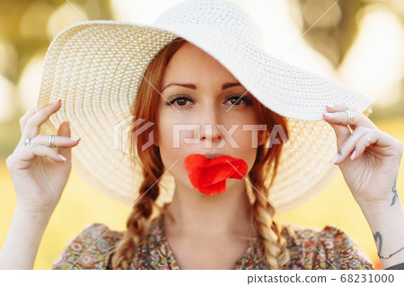 Portrait of beautiful redhead woman in white hat 68231000