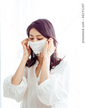 Young asian woman wearing Surgical mask to prevent 68231287
