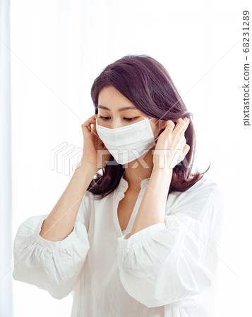Young asian woman wearing Surgical mask to prevent 68231289