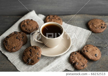 Coffee cup with cookies and chocolate on wooden table background. Mug of black coffee with chocolate cookies. Fresh coffee beans. Coffee cup with cookies and chocolate on wooden table background. Mug of black coffee with chocolate cookies. Fresh coffee beans. 68232513