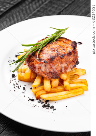 Steak medallion with French fries on a white plate. Steak medallion with French fries on a white plate. 68234553