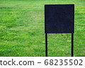 Closeup black metal sign at green grass background, nameplate with a space for your text, copyspace, empty space for inscription 68235502