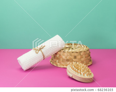 Towel and massage brush in a wicker basket on a 68236103