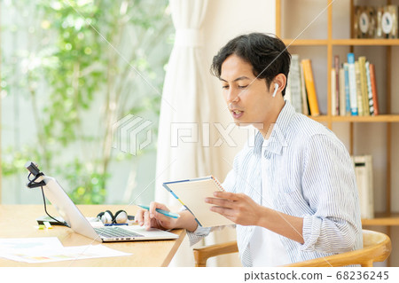 一個年輕人在客廳裡做遠程辦公 68236245