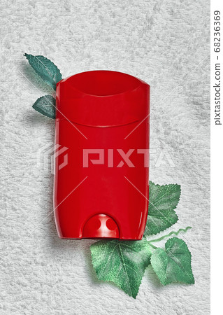 red solid deodorant on a white towel with artificial foliage .mocap, flat lay, top view, close up, copy space red solid deodorant on a white towel with artificial foliage .mocap, flat lay, top view, close up, copy space 68236369